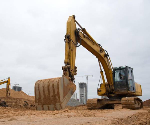 Yellow excavator digging soil at construction site for Excavation Service 